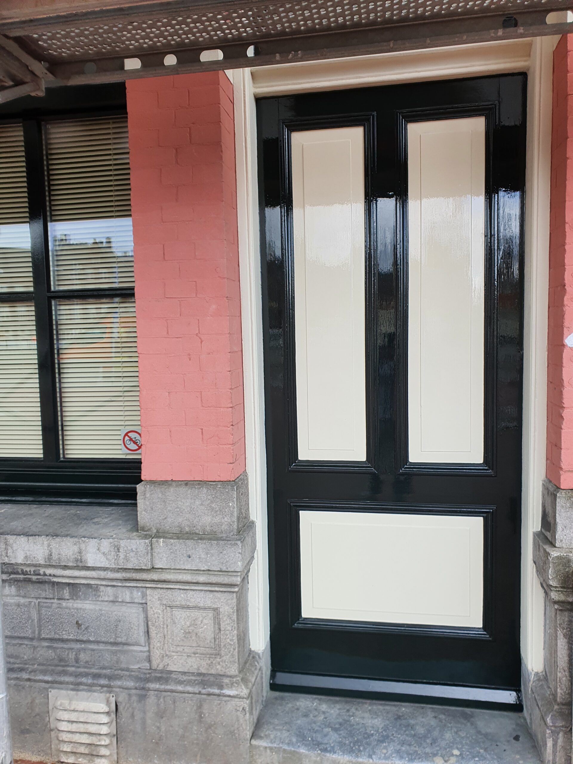 Gevel in oudroze met klassiek schilderwerk in Amsterdam